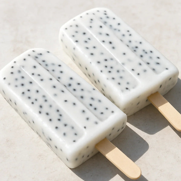White coconut milk ice lollies with black sabja seeds each with white gel coating suspended throughout