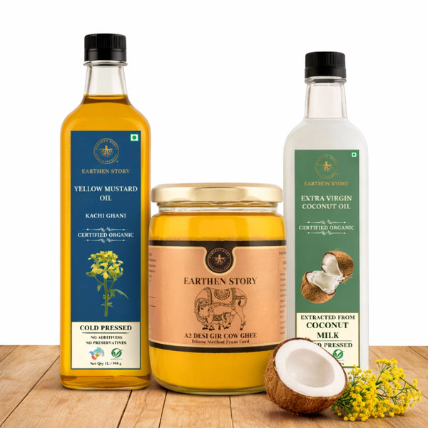 Everyday Cooking Base Bundle with a2 gir cow ghee, yellow mustard oil, and extra virgin coconut oil on a plain white background on a wooden desk.
