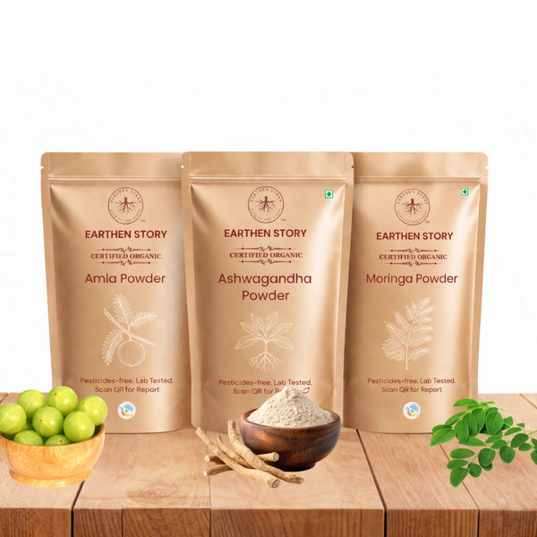 Herbal Wellness Starter Bundle with ashwagandha powder, moringa powder, and amla powder on a plain white background on a wooden desk.