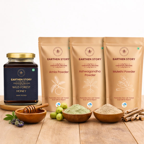 Immunity & Strength Bundle with wild forest honey, ashwagandha powder, mulethi powder, and amla powder on a plain white background on a wooden desk.